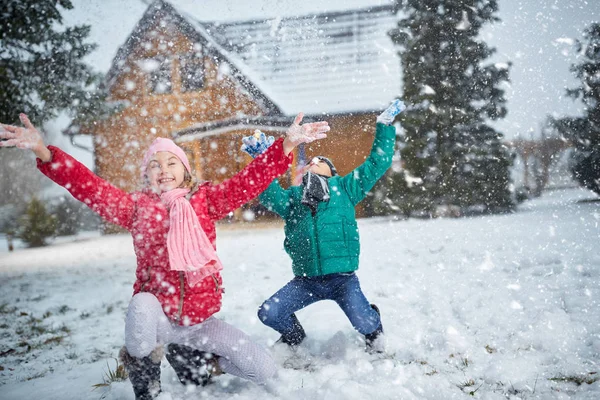 Children playing on snow in winter holiday — Stock Photo, Image
