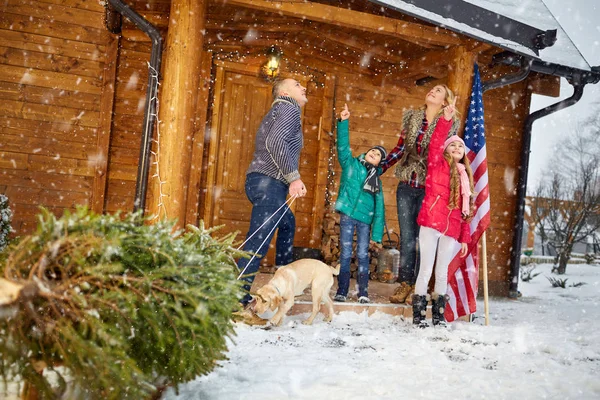 Happy family with Christmas tree on snowy day — Stock Photo, Image