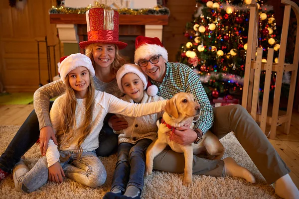 Retrato familia y perro sentado por árbol de Navidad — Foto de Stock