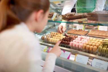 Kız şekerleme dükkanında macarons seçin