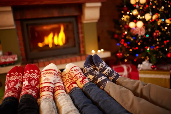 Pieds de famille en chaussettes de laine près de la cheminée en hiver — Photo