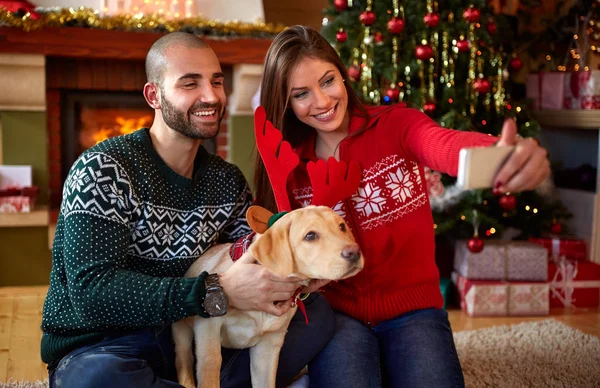 Ζευγάρι με σκύλο λαμβάνοντας αυτοπορτρέτα στις διακοπές των Χριστουγέννων — Φωτογραφία Αρχείου