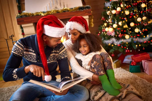Joven papá leyendo un libro a linda hija cerca de árbol de Navidad — Foto de Stock