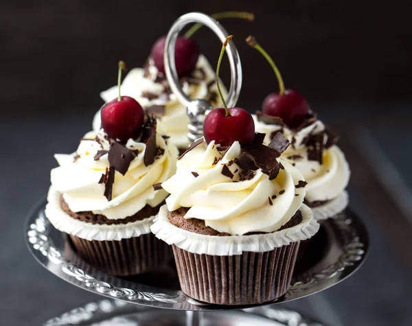 Belos cupcakes de chocolate com creme branco e cereja — Fotografia de Stock