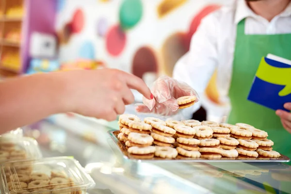 Молодий покупець на роботі продає солодощі клієнту — стокове фото
