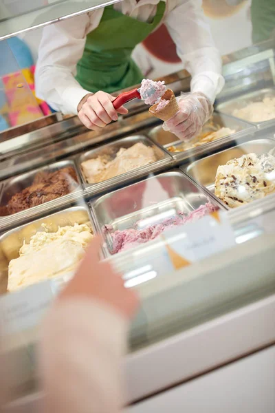 Filling cones with ice cream from glass case — Stock Photo, Image