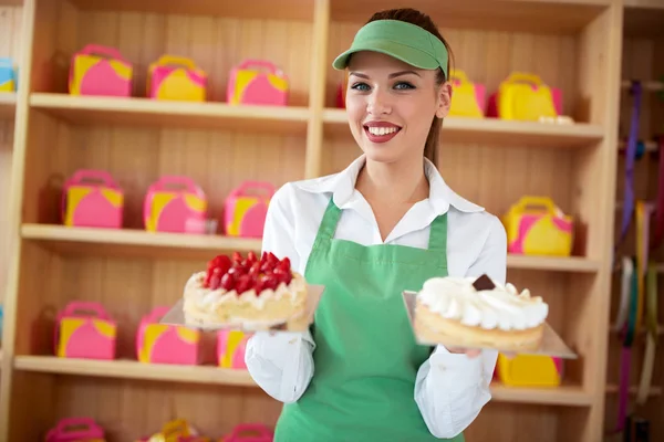 Vendor in pastry shop hold two nice cakes in hands — Stock Photo, Image