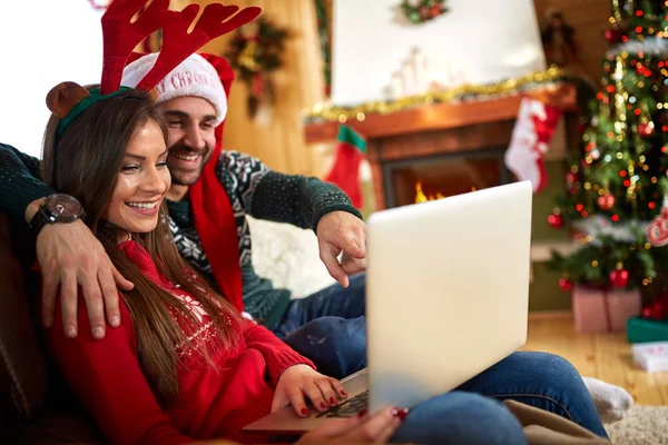 Man och kvinna på jullov med laptop Stockfoto