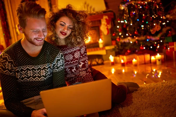 Casal olhando no laptop à noite — Fotografia de Stock