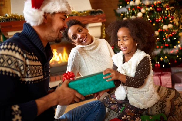 Riendo familia afro-americana intercambiando regalos por Navidad — Foto de Stock