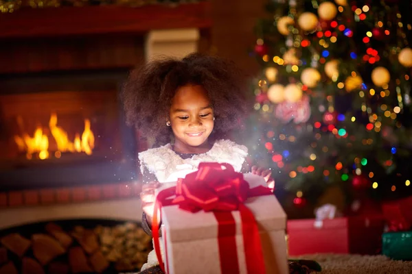 Glückliche Mädchen suchen in offenen magischen Weihnachtsgeschenk — Stockfoto