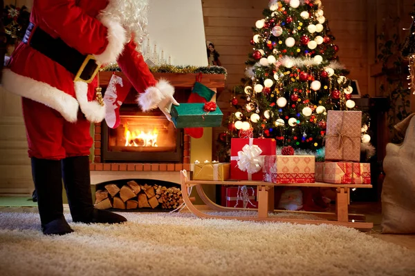 Papai Noel deixa um presente sob a árvore de Natal — Fotografia de Stock
