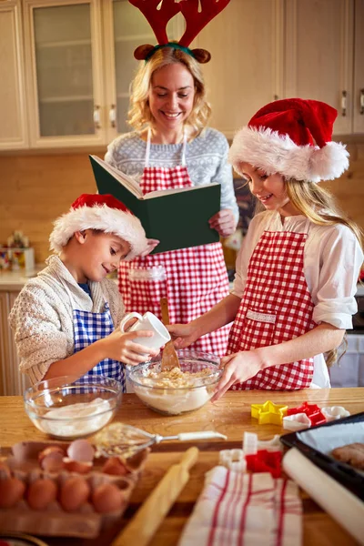 Madre ayudando a los niños a hacer galletas de Navidad — Foto de Stock