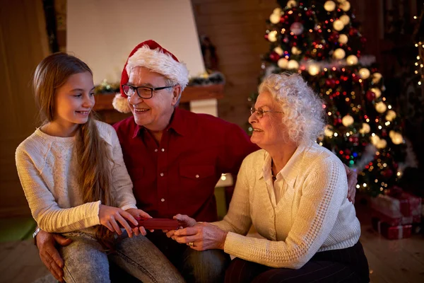 Παππούδες και γιαγιάδες δίνοντας δώρα εγγονή κατά την παραμονή των Χριστουγέννων — Φωτογραφία Αρχείου