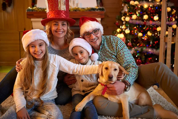 Porträt einer glücklichen Familie und des Hundes, der zusammen Weihnachten verbringt — Stockfoto