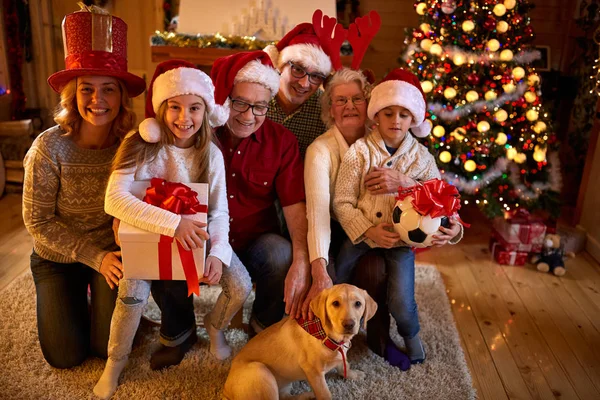 Lachende gezin met giften en hond bij xmas — Stockfoto