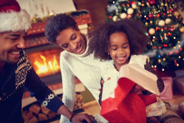Glücklich lächelnde afrikanisch-amerikanische Familie in weihnachtlicher Atmosphäre — Stockfoto