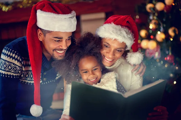 Jóvenes afro familia americana juntos leyendo cuentos de hadas de Navidad — Foto de Stock