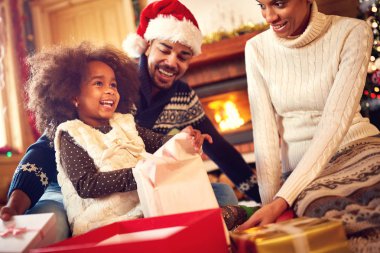 Mutlu bir Afro-Amerikan aile Noel hediyesi açma