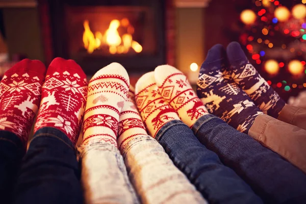 Famille en chaussettes près de la cheminée en hiver — Photo