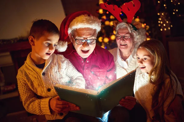 Family reading Christmas magic book — Stock Photo, Image