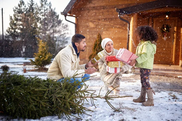 Ouders met zwarte dochter brengen vakken met giften van Kerstmis — Stockfoto