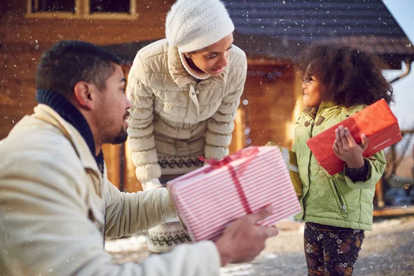 Kind hält Weihnachtsgeschenke in der Hand, die von den Eltern erhalten werden — Stockfoto