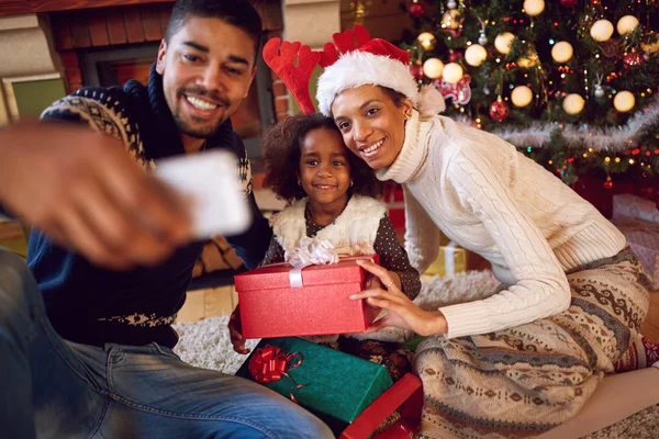 Счастливая семья делает автопортрет со смартфоном на Рождество — стоковое фото