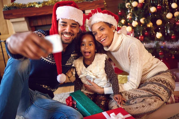 Happy family taking self portrait with smartphone during Christms — Stock Photo, Image