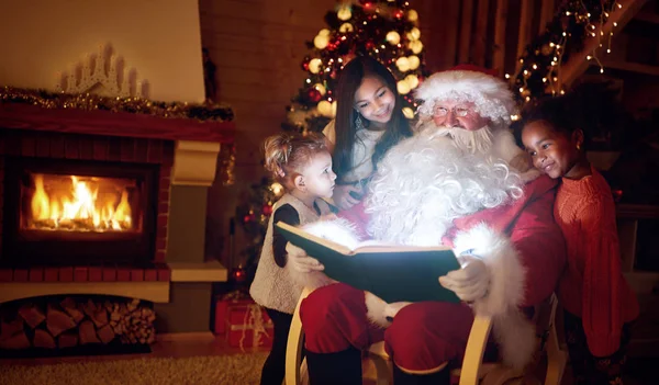 Santa Claus čtení knihy kouzel s dětmi — Stock fotografie