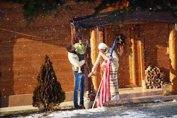 Familie versieren huis van buiten met kerstverlichting — Stockfoto