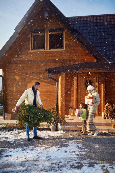 Parents with kid bringing gifts and fire for Christmas — Stock Photo, Image