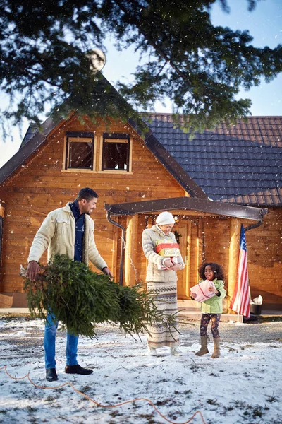 Lycklig familj förbereder mountain house till jul — Stockfoto