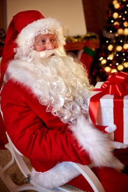 Oturma ve büyük bir kutu hediye ile tutarak Noel