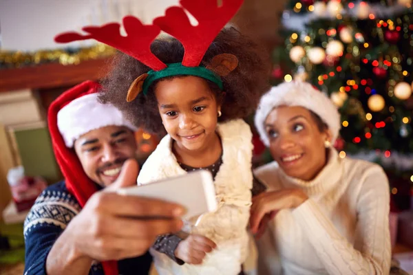 Família feliz tirando selfie durante o Natal — Fotografia de Stock
