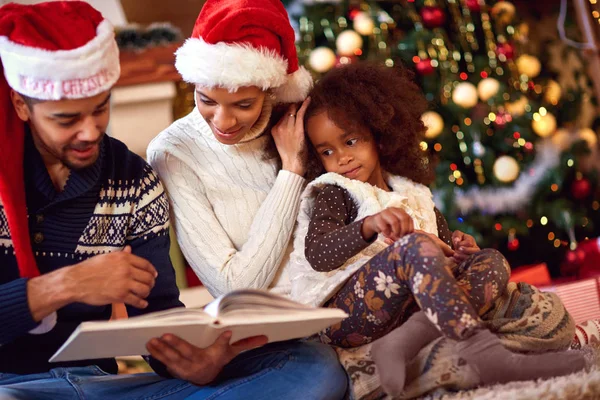 Familia afroamericana mira libro para Navidad — Foto de Stock