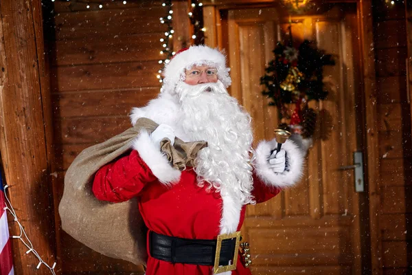 Portrait of Santa Claus holding his bag and ringing a bell it's — Stock Photo, Image