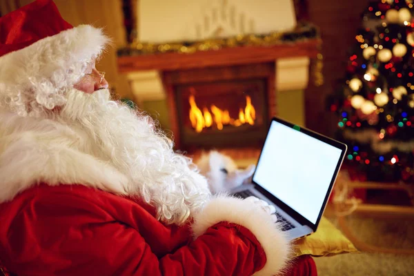 Santa Claus leyendo correo electrónico en el ordenador portátil con la Navidad solicitando —  Fotos de Stock