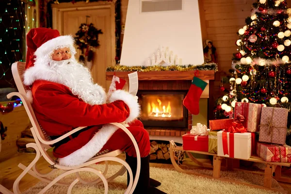 Papá Noel disfrutando y leyendo los deseos de los niños para x-mas —  Fotos de Stock