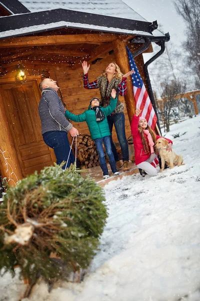 Familia sonriente con árbol de Navidad en el día nevado — Foto de Stock