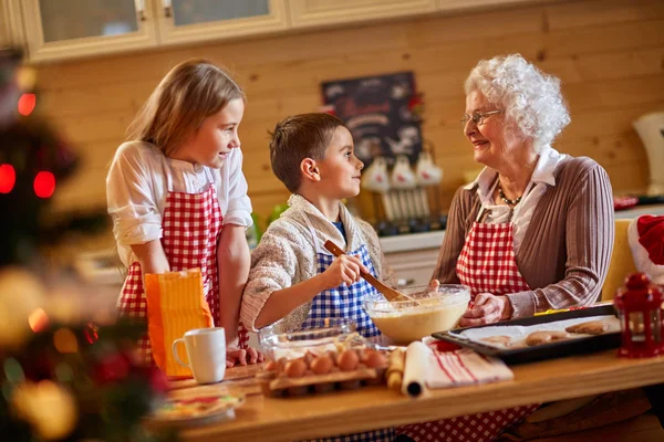 Улыбающиеся дети и бабушка готовят рождественское печенье — стоковое фото