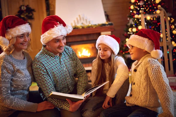 Heiligabend - glückliche Familienzeit. Familie liest Buch — Stockfoto