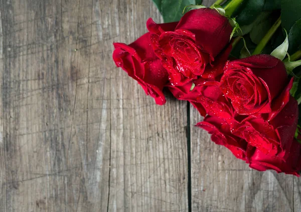 Belas rosas vermelhas no fundo de madeira — Fotografia de Stock