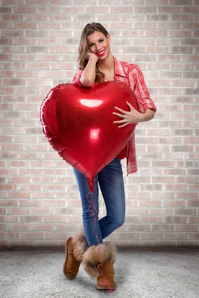 Amor chica abrazando grande rojo corazón — Foto de Stock