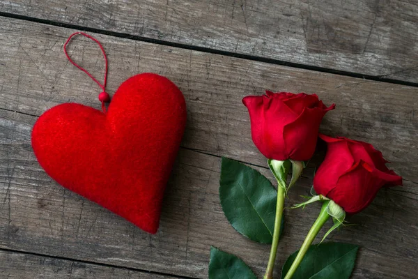 Rosas rojas y corazón rojo sobre mesa de madera —  Fotos de Stock