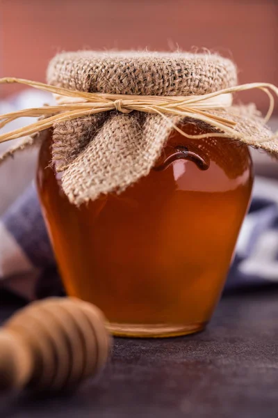 Honig mit hölzernem Honiglöffel in Schüssel auf dem Tisch — Stockfoto