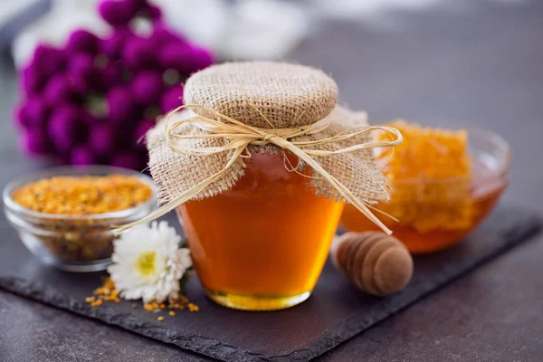 Мед с ковшом из меда в миске на столе — стоковое фото