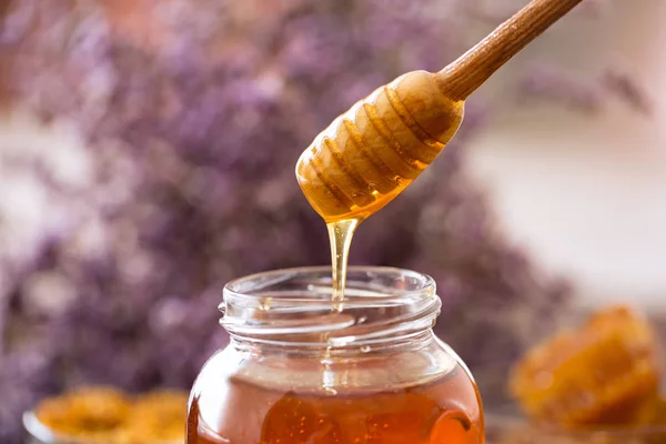 Tropfender süßer goldener Honig aus dem Holzdipper — Stockfoto