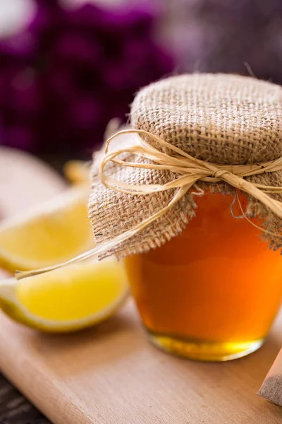 Сладкий мед в стеклянной банке и лимоне — стоковое фото