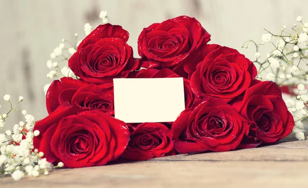 Ramo de rosas rojas sobre mesa de madera —  Fotos de Stock